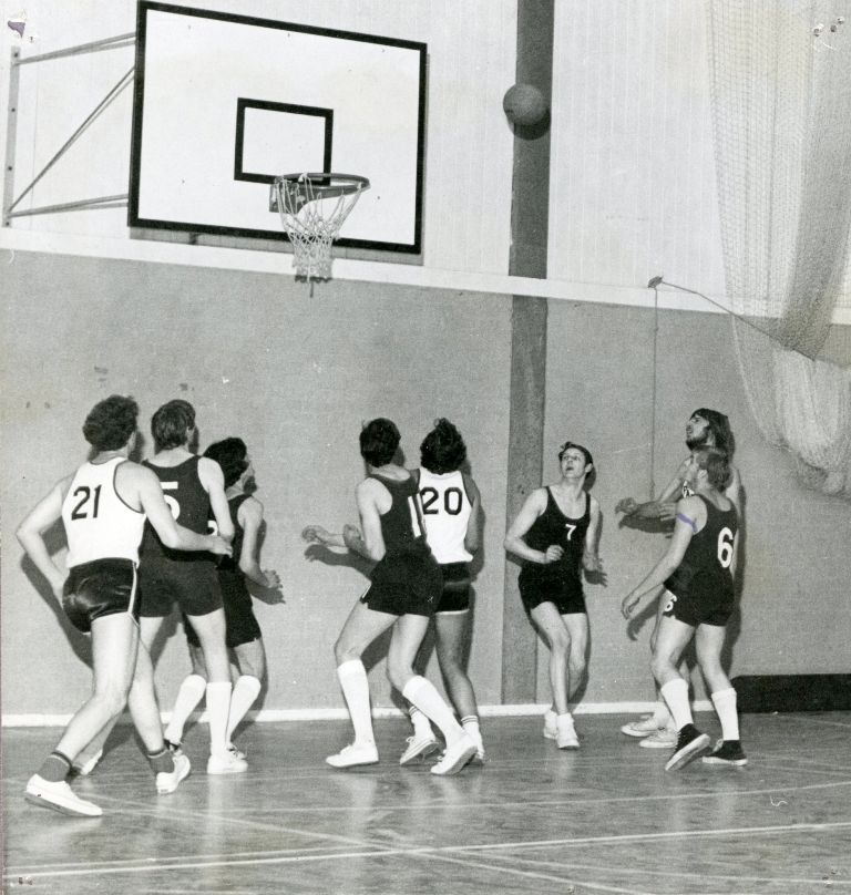black and white photo of a group of men plating netball