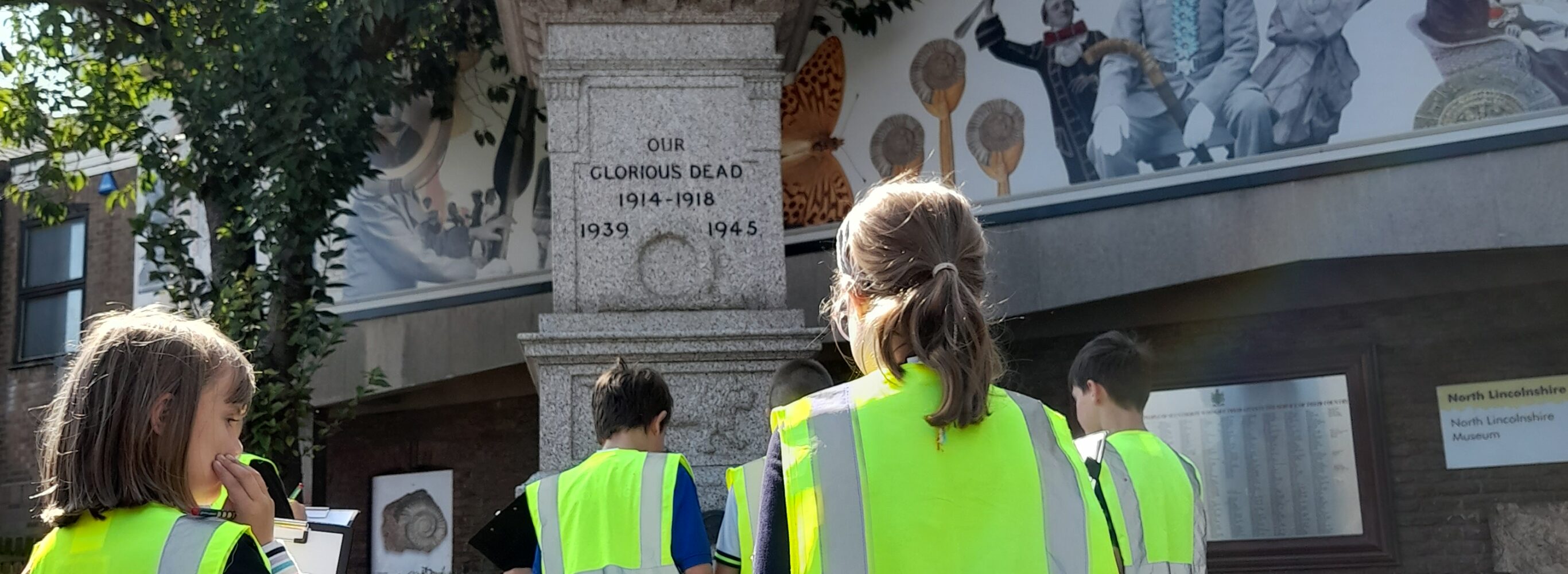 3 boys and 2 girls stood infront of the war memorial at the front of the Museum.