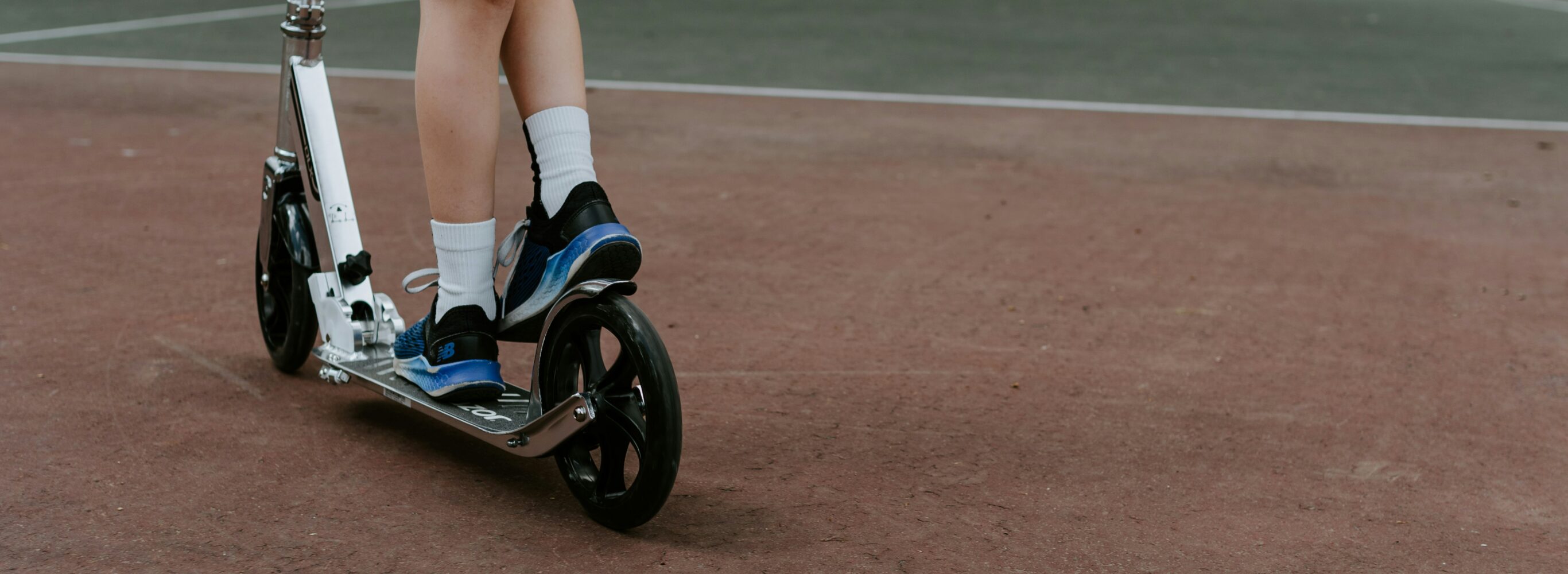 close up of child's legs riding a scooter