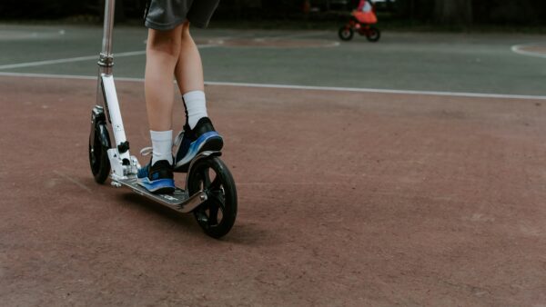 close up of child's legs riding a scooter