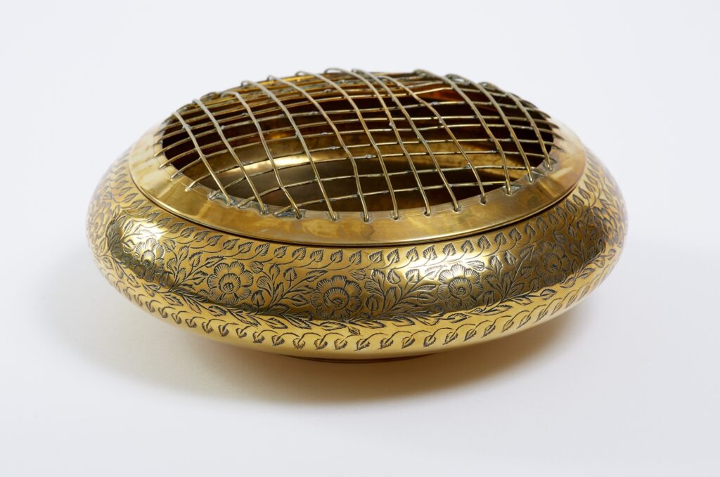 A gold bowl with a mesh lid.
