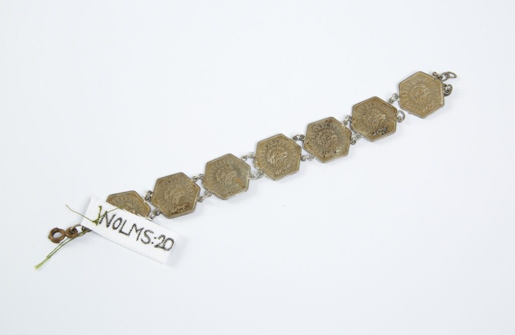 A gold braclet made of square plaques linked by chains.