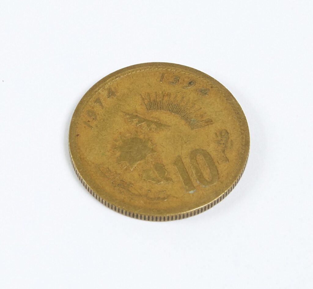 Copper coloured coin with the number 10 in large letters.